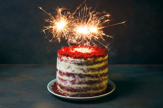 Compleanno di dessert festivo o torta di velluto dairato di San Valentino con fuochi d'artificio