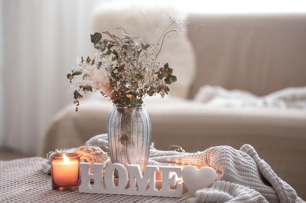 Composizione accogliente con candele decorative per la casa e vaso con fiori secchi