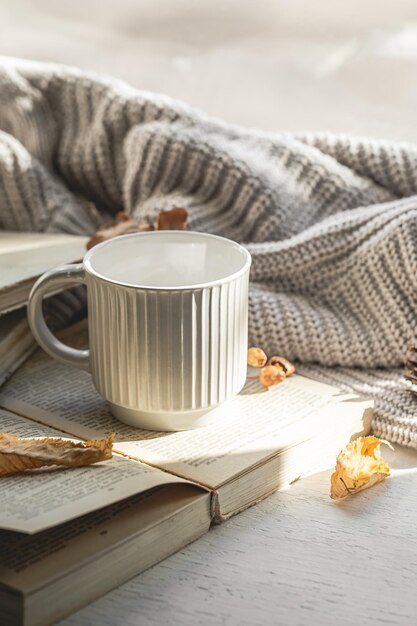 Composizione autunnale con una tazza testurizzata e un libro sul davanzale della finestra