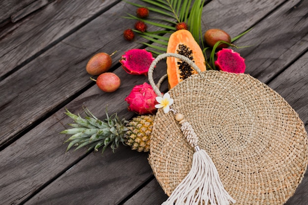 Composizione con frutti tropicali in sacchetto di paglia