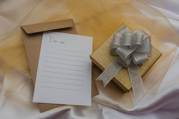 Composizione del giorno del padre con regalo e carta per scrivere un messaggio