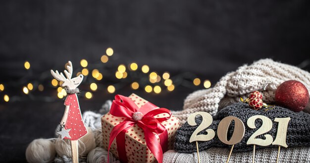 Composizione del nuovo anno con il numero di capodanno in legno e decorazioni natalizie su uno sfondo scuro.