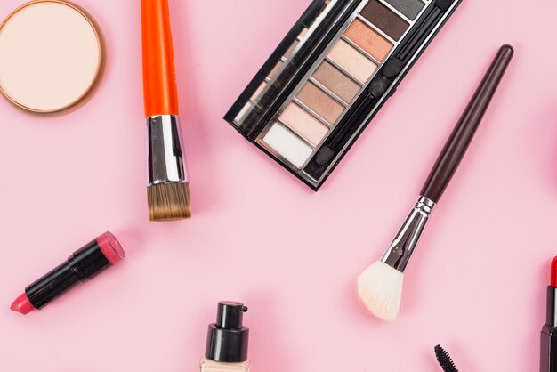 Composizione del trucco e prodotti di bellezza cosmetici posa su sfondo rosa