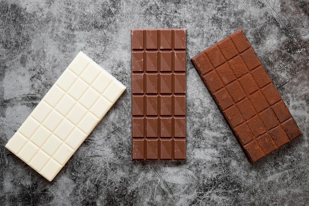 Composizione di cioccolato creativo piatto laici su sfondo scuro