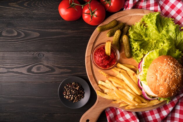 Composizione di deliziosi hamburger e patatine fritte con copia spazio