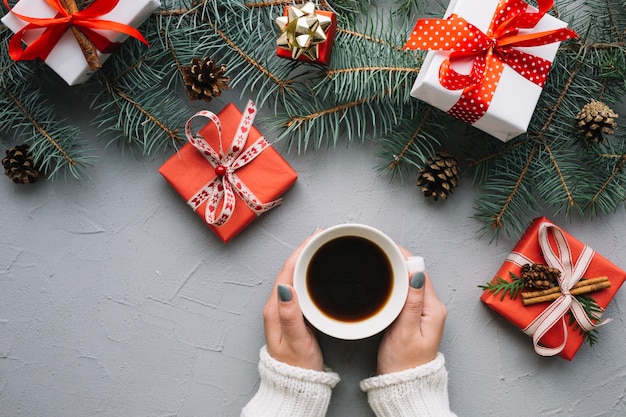 Composizione di Natale con le mani che tengono il caffè