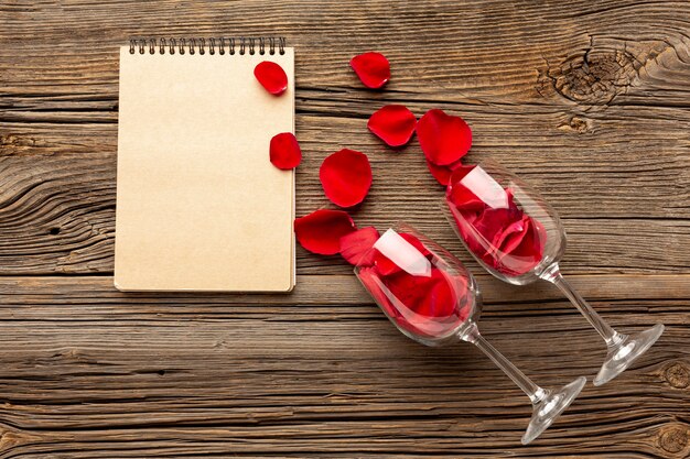 Composizione di San Valentino vista dall'alto con blocco note e petali vuoti