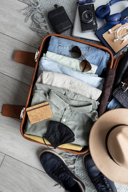 Composizione di vestiti e accessori in valigia