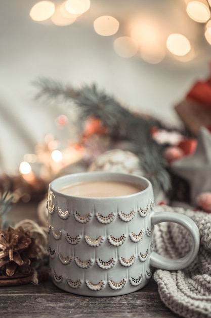 Composizione festiva con tazza su una superficie di legno con luci