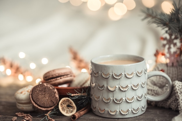 Composizione festiva con tazza su una superficie di legno con luci