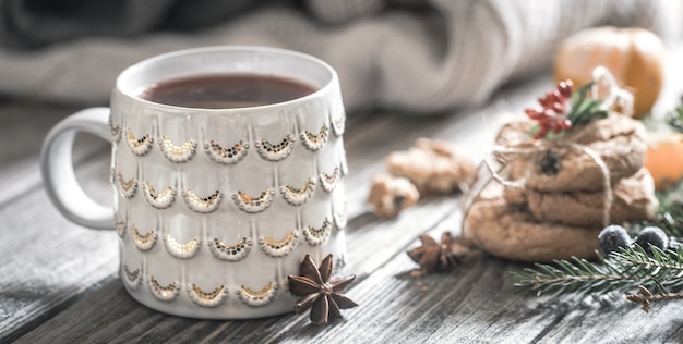 Composizione in Natale con tazza di tè e biscotti su uno sfondo di legno, il concetto di vacanza e divertimento, lo sfondo