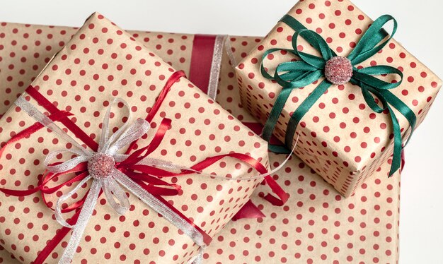 Composizione natalizia di varie scatole regalo avvolte in carta artigianale e decorate con nastri di raso. Vista dall'alto, piatto.
