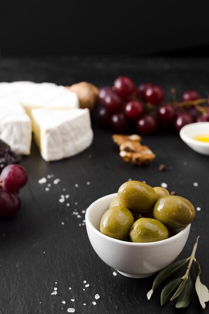Composizione nel formaggio e nelle olive dell'angolo alto su fondo nero