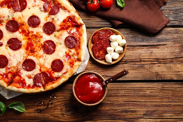 Composizione piatta con pizza ai peperoni caldi sul tavolo di legno