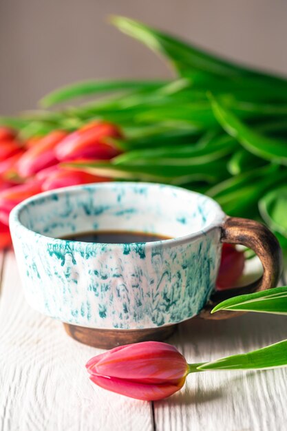 Composizione primaverile con una tazza di caffè e tulipani