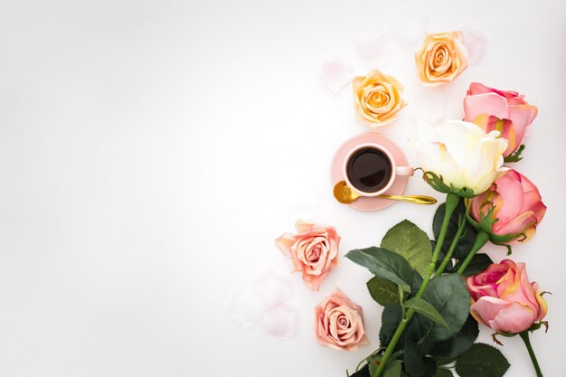 Composizione romantica con rose, petali e tazza di caffè rosa con spazio di copia