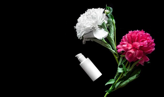 Composizione spa con bottiglie vuote per cosmetici e peonie