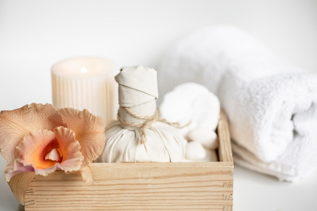 Composizione spa con prodotti per la cura del corpo in una scatola di legno e fiori di orchidea tailandese