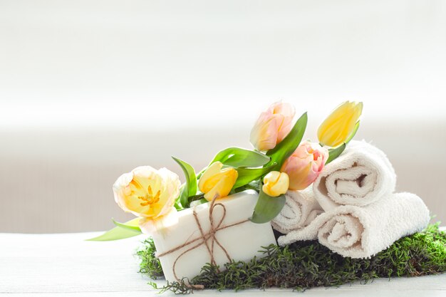 Composizione Spring Spa con articoli per la cura del corpo con tulipani freschi su luce, bellezza e salute.