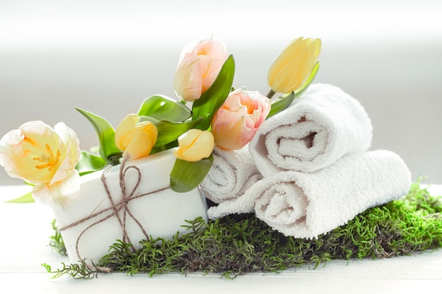 Composizione Spring Spa con articoli per la cura del corpo con tulipani freschi su sfondo chiaro, bellezza e salute.