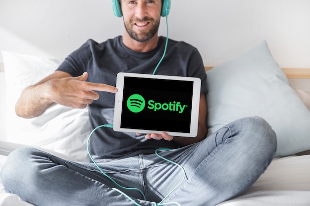 Compressa della tenuta del giovane con l&#39;app di spotify