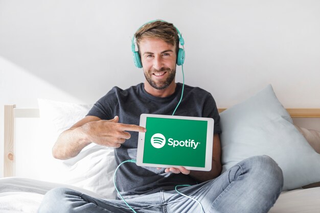 Compressa della tenuta del giovane con l&#39;app di spotify