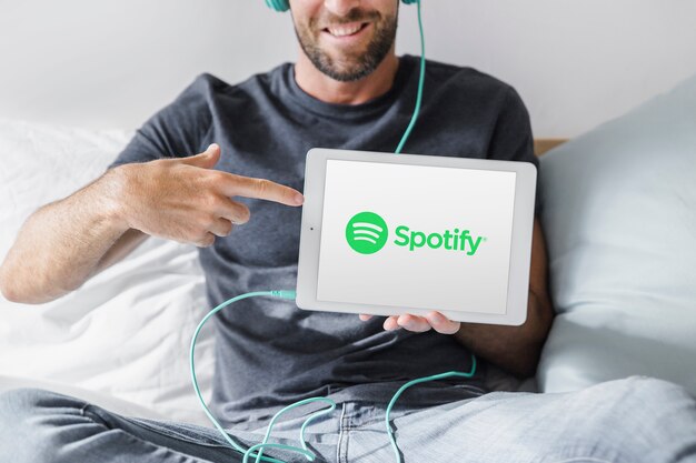 Compressa della tenuta del giovane con l&#39;app di spotify