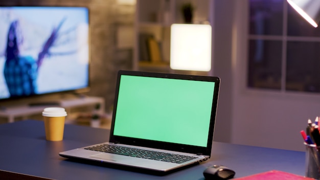 Computer desktop con schermo verde in ufficio a casa. Uomo d'affari in background.