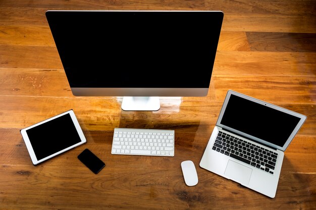 Computer, laptop e tablet vista dall&#39;alto su un tavolo di legno