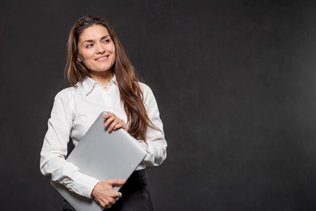 Computer portatile della tenuta della donna di angolo basso