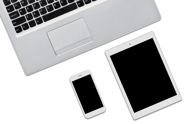 Computer portatile, tablet e cellulare isolato su bianco con spazio di copia per la tua pubblicità o testo promozionale. Tre dispositivi moderni con schermi vuoti. Vista dall'alto di gadget aggiornati.