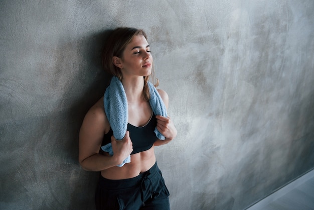 Con gli occhi chiusi. Foto della splendida donna bionda in palestra durante il fine settimana