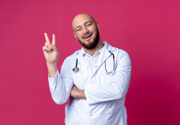 Con gli occhi chiusi soddisfatto il giovane medico maschio che indossa la veste medica e lo stetoscopio