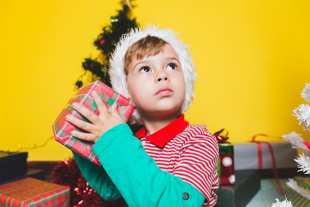 Concepto di Natale con con il ragazzo che scuote la scatola attuale