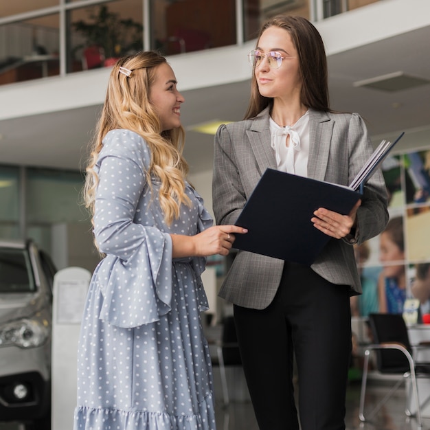 Concessionario auto parlando con donna bionda