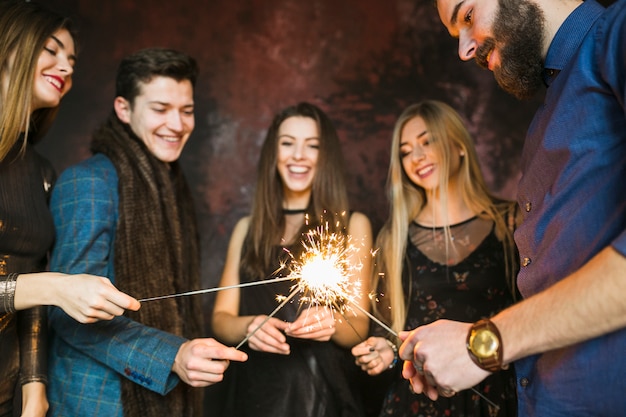 Concetto del partito e di amicizia di nuovo anno con lo sparkler