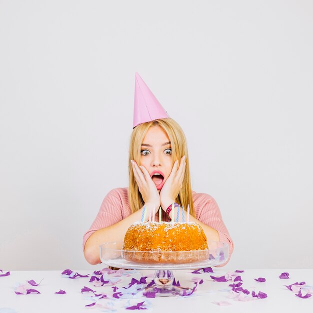 Concetto della torta di compleanno con la donna sorpresa