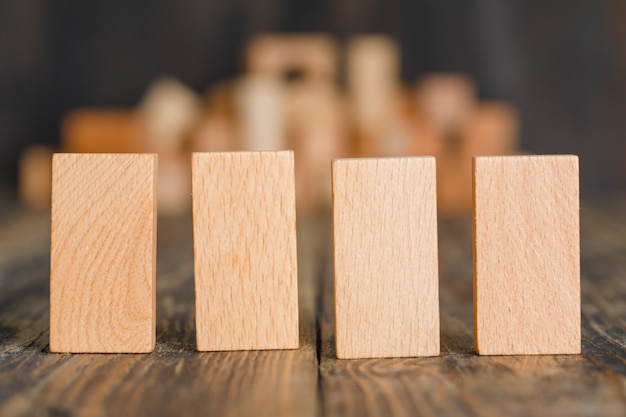 Concetto di affari con i blocchi di legno sulla vista laterale della tavola di legno.