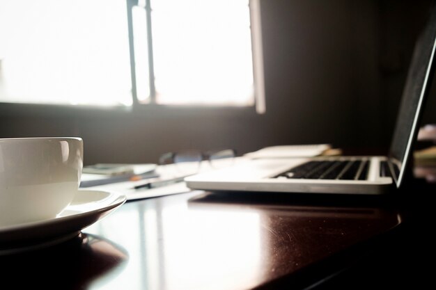 Concetto di affari con spazio di copia. Tavolo da ufficio con penna e diagramma di analisi, computer, taccuino, tazza di caffè sullo scrittorio. Tono di vernice Retro filtro, messa a fuoco selettiva.