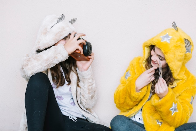 Concetto di amicizia di due ragazze con fotocamera