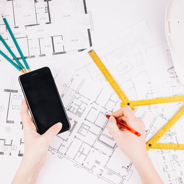 Concetto di architettura con piano di costruzione e smartphone