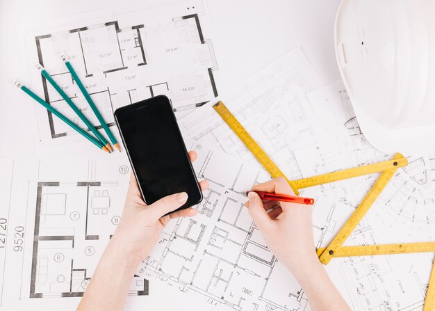 Concetto di architettura con piano di costruzione e smartphone