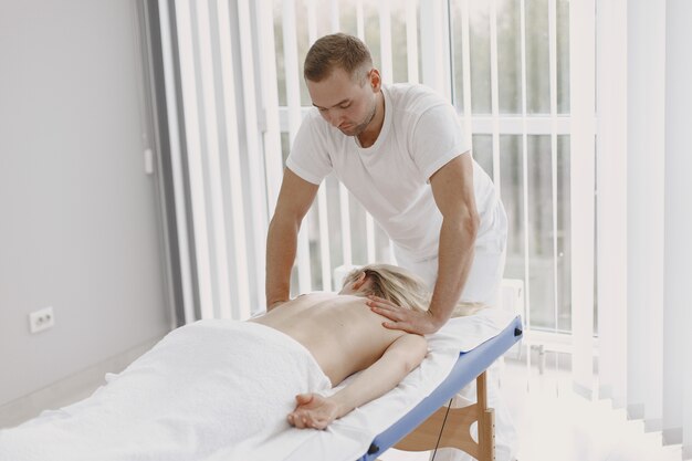 Concetto di assistenza sanitaria e bellezza femminile. Le massaggiatrici fanno un massaggio a una ragazza. La donna in un salone spa.