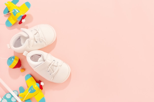 Concetto di bambino. Accessori piatti con scarpe per bambini e aereo giocattolo in legno.