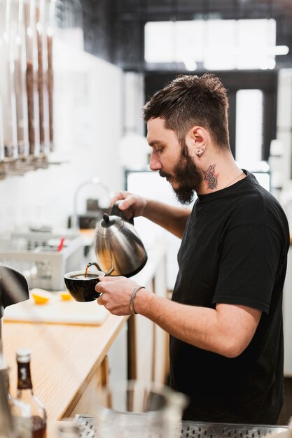 Concetto di bar con barman fare caffè