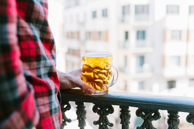 Concetto di birra con uomo sul balcone