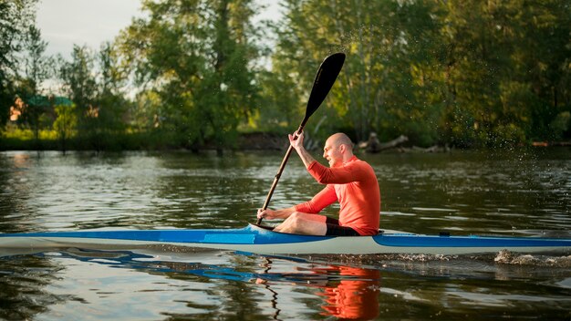 Concetto di canottaggio con l'uomo in canoa