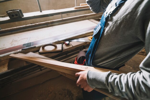 Concetto di carpenteria con legno commovente dell&#39;uomo