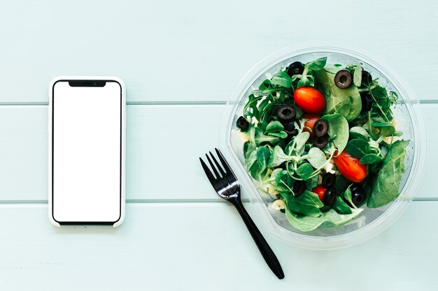 Concetto di cibo sano con smartphone e insalata