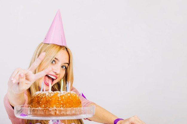 Concetto di compleanno con ragazza che fa il segno di vittoria